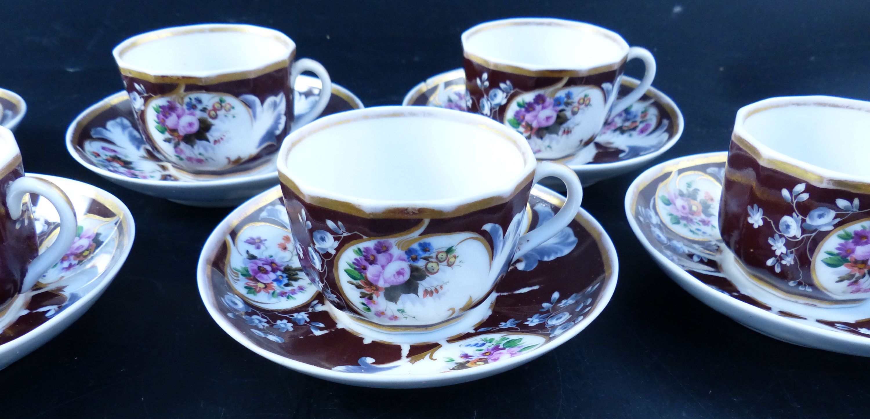 A set of seven Continental porcelain tea cups and saucers